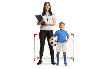 Wall Mural - Boy with a female football coach posing in front of a mini goal