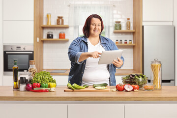 Canvas Print - Woman with a digital tablet looking for an online recipe