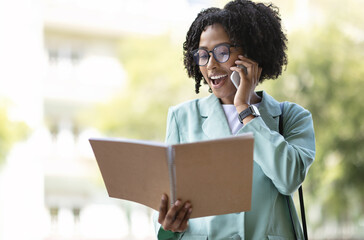 Wall Mural - Cheerful young african woman counselor have phone conversation with client