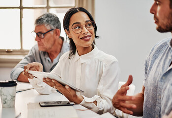 Poster - Teamwork makes a big difference in business. Shot of a group of businesspeople using a digital tablet during a meeting in a modern office.