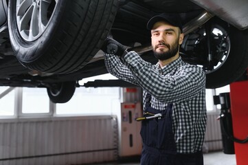 Wall Mural - Handsome Car Mechanic is Posing in a Car Service.