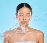 Fototapeta  - Skincare, water splash and face of woman on blue background for wellness, healthy skin or cleaning. Bathroom, shower and eyes closed of female person for facial grooming, washing and beauty in studio
