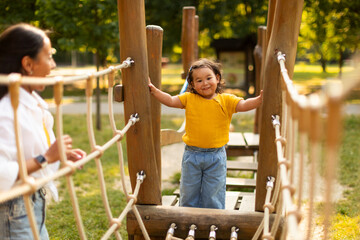 Wall Mural - Japanese Baby Girl With Mommy On Playground Walking Swinging Bridge