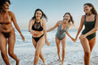 © Prostock-studio - Happy young diverse women having fun on the beach, running in water and laughing, enjoying summer time together