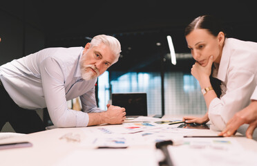 Wall Mural - Businesswoman and senior colleague discussing strategy in office