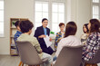 © Studio Romantic - Smiling friendly female teacher talking to children in classroom. Group of school students in casual wear and female teacher sitting on chairs in circle and interacting during lesson at school