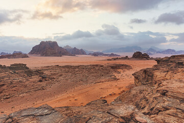 Red orange Mars like landscape in Jordan Wadi Rum desert, mountains background, overcast morning. This location was used as set for many science fiction movies