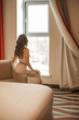 © Ирина Сергеенкова - Young smiling woman enjoying new bestseller book sitting on window sill, happy book lover reading fiction literature relaxing at home, student teenager study textbook in modern cozy loft bedroom