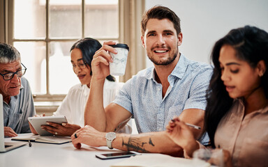 Poster - An indispensable part of a productive team. Portrait of a young businessman having coffee during a meeting with colleagues in a modern office.