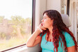 © Sangiao_Photography - Train traveler. Hispanic mid-adult woman looking through the window on holiday lifestyle vacation