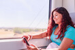 © Sangiao_Photography - Train traveler. Hispanic mid-adult woman looking smartphone on holiday lifestyle vacation