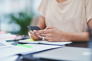 Poster - The digital age demands one to stay connected. Closeup shot of an unrecognisable designer using a cellphone in an office.