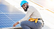 © JessicaLeigh J/peopleimages.com - Black man, portrait and technician in solar panel installation on rooftop in city for renewable energy. Happy African male person, engineer or contractor working on roof in sun for electricity power