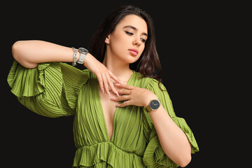 Wall Mural - Beautiful young woman with wristwatches on black background