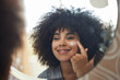 © Alexis Scholtz/peopleimages.com - Beauty, cream and skincare with woman in mirror for product, facial and cosmetics. Morning routine, reflection and self care with face of female person and lotion at home for sunscreen and glow