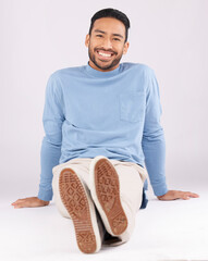 Poster - Portrait, fashion and man smile on the floor in studio isolated on a white background. Style, happy and Asian person from Cambodia in casual clothes, trendy aesthetic or confidence to relax on ground
