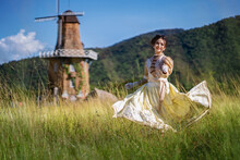 Teenage Girl In Old Fashion Style Costumes Running With Happy In The Yellow Field. Vintage Blouse Costume. Historical Dresses, Victorian Or Edwardian Era Style Dress