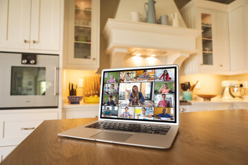 Poster - Laptop with video conference with caucasian female teacher and diverse students on kitchen table