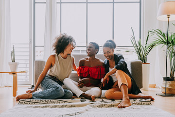 Wall Mural - Beautiful and young latin american women having fun and bonding at home - Three pretty hispanic adult female spending time together 