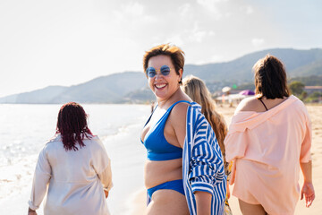 Wall Mural - Group of plus size women with swimwear at the beach - Multiethnic curvy adult female having fun and sunbathing on summertime vacation, concepts about beauty, body positivity and self acceptance