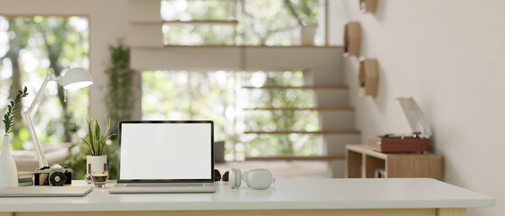 Sticker - a modern home office workspace with a laptop and accessories on a white tabletop.