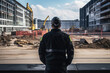 © Anastasiia - Security Guard In Black Stands With His Back To Construction Sites