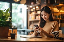 Effortless Online Retail Shopping: Young Asian Woman Successfully Completes Payment Transaction With Credit Card On Smartphone And Laptop At Coffee Cafe: Generative AI