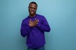© Ivan Traimak - authentic handsome young african man in blue sweater on blue background with copy space