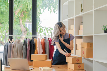 Wall Mural - Small business owner, entrepreneur, seller checking ecommerce clothing store orders working in her office. Online sales