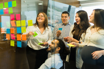 diverse working team brainstorming new project ideas using sticky notes