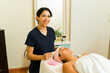 © AntonioDiaz - Cheerful therapist giving a skin care facial treatment
