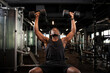 © Богдан Маліцький - athletic african american man trains in dark gym, athletic guy lifts heavy dumbbells in fitness club