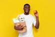 © Богдан Маліцький - joyful male african american shopper holding eco bag with groceries and smiling