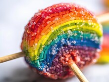 The Image Displays A Bright, Rainbow-colored Lollipop, With A Fun, Exaggerated Shape, Set Against A Bright White Background. The Lollipop Fills The Frame In A Close-up Shot, Showcasing Its Vibrant Col