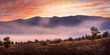 canvas print picture - Morgennebel vor einer Bergkette zum Sonnenaufgang