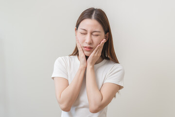 Wall Mural - Face expression suffering from sensitive teeth and cold, asian young woman, girl feeling hurt, pain touching cheek, mouth with hand. Toothache molar tooth, dental problem isolated on white background.