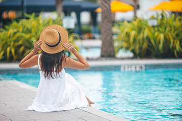 Poster - Young beautiful woman enjoying summer vacation in infinity luxury swimming pool