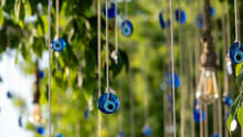 Blue Evil Eye Beads Hanging With A Rope From A Tree Branch. Traditional Evil Eye Amulet. A National Symbol And Guardian In Turkey.