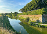 Fototapeta Do pokoju - River and stone wall near Palmanova town in Italy