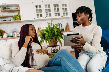 Young black women talking and using tablet computer