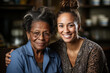 Caregiver woman sitting beside a contented elderly black woman
