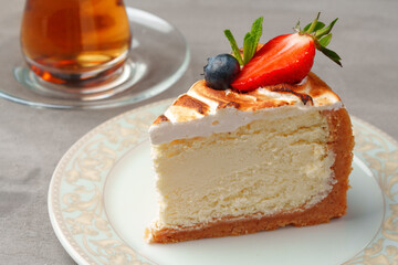 Wall Mural - Piece of cake on plate with cup of tea on gray table