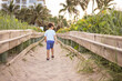 © Tamara Sales  - boy walking in the board walk at a Beach in palm beach florida singer island by the ocean point