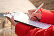 © Nattawit - The civil engineer is checking the building quality report checklist form with construction work site as background. Industrial working action scene with people, close-up and selective focus.