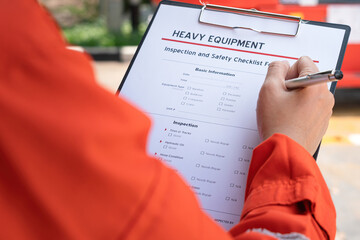 Wall Mural - the maintenance engineer is checking the heavy equipment checklist form to verify the status. indust