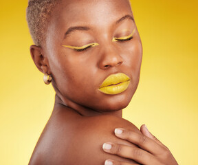 Poster - Creative, makeup and woman in a studio with cosmetic eyeliner and lipstick for cosmetology. Self care, glamour and young African female model with a colorful face routine by a yellow background.