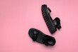 Black leather summer womens sandals on pink background. Fashionable casual stylish trendy female shoes, rough sandals with thick soles. Minimalistic concept, foot advertising. Flat lay top view 