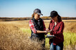 © Designpics - A woman farmer standing in the fields teaching her apprentice about modern farming techniques for canola crops using wireless technologies and agricultural software; Alcomdale, Alberta, Canada
