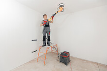 Painter Work With White Ceiling Polishing And Sanding Surface After Putty For Painting