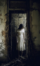 Female Ghost Woman In A Abandoned Room Entrance. Grunge Walls. White Dress. Pale Skin.
